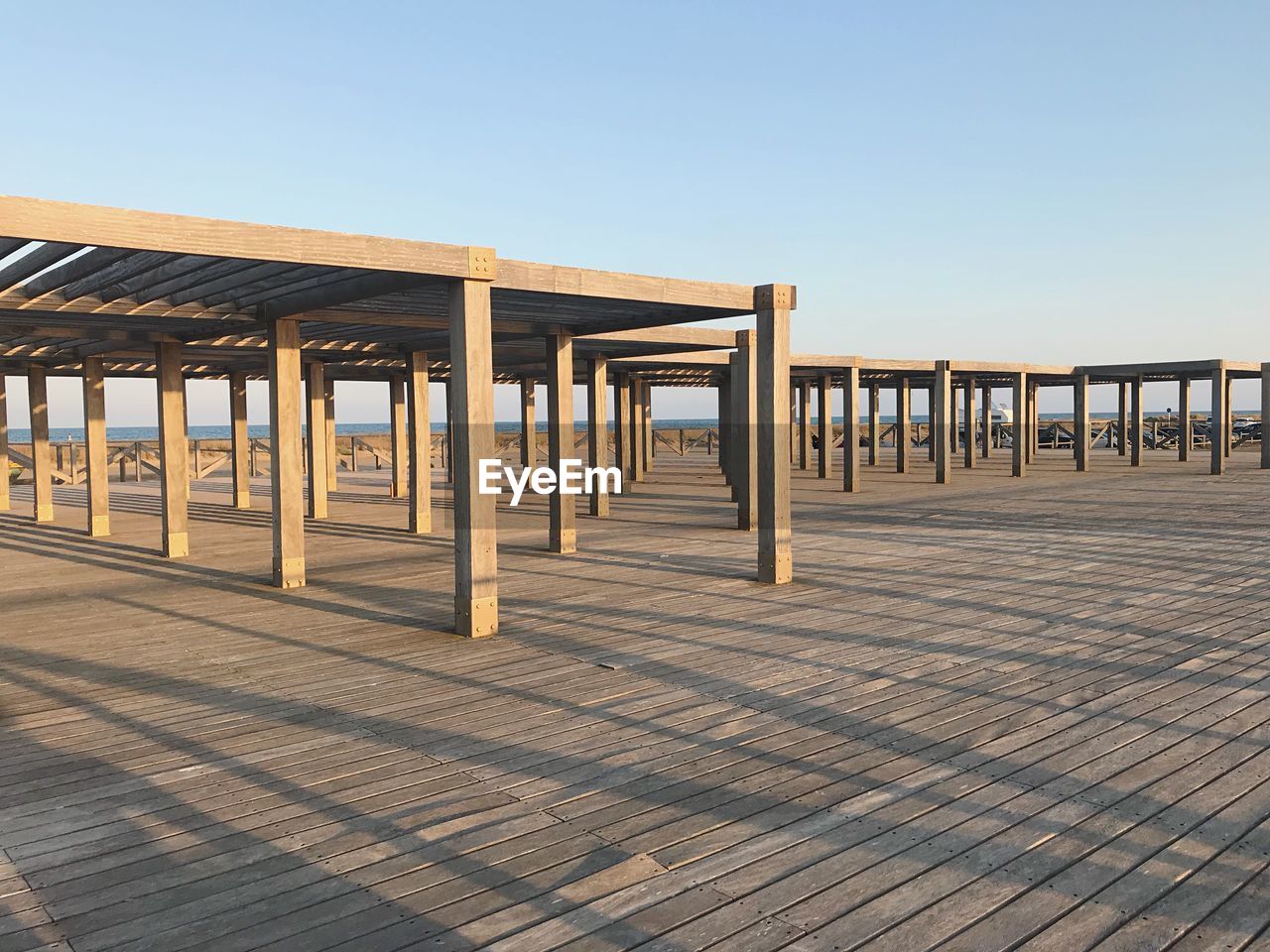 Wooden posts on beach against clear sky