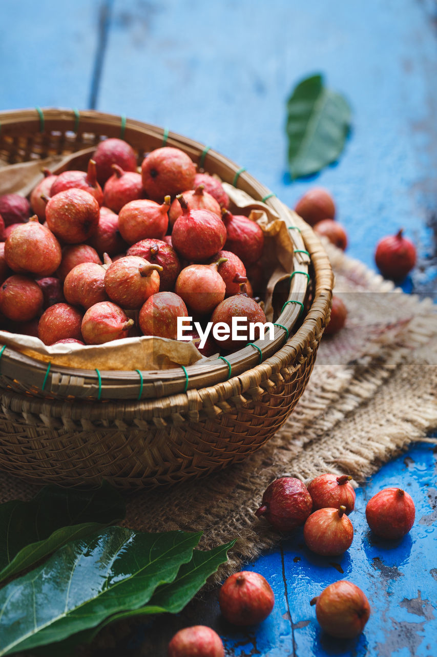 Figs in wicker basket on wooden table