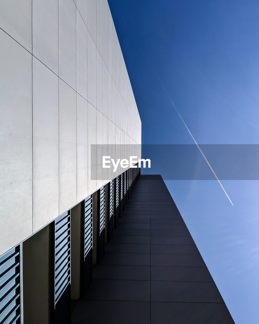 Low angle view of modern building against clear blue sky