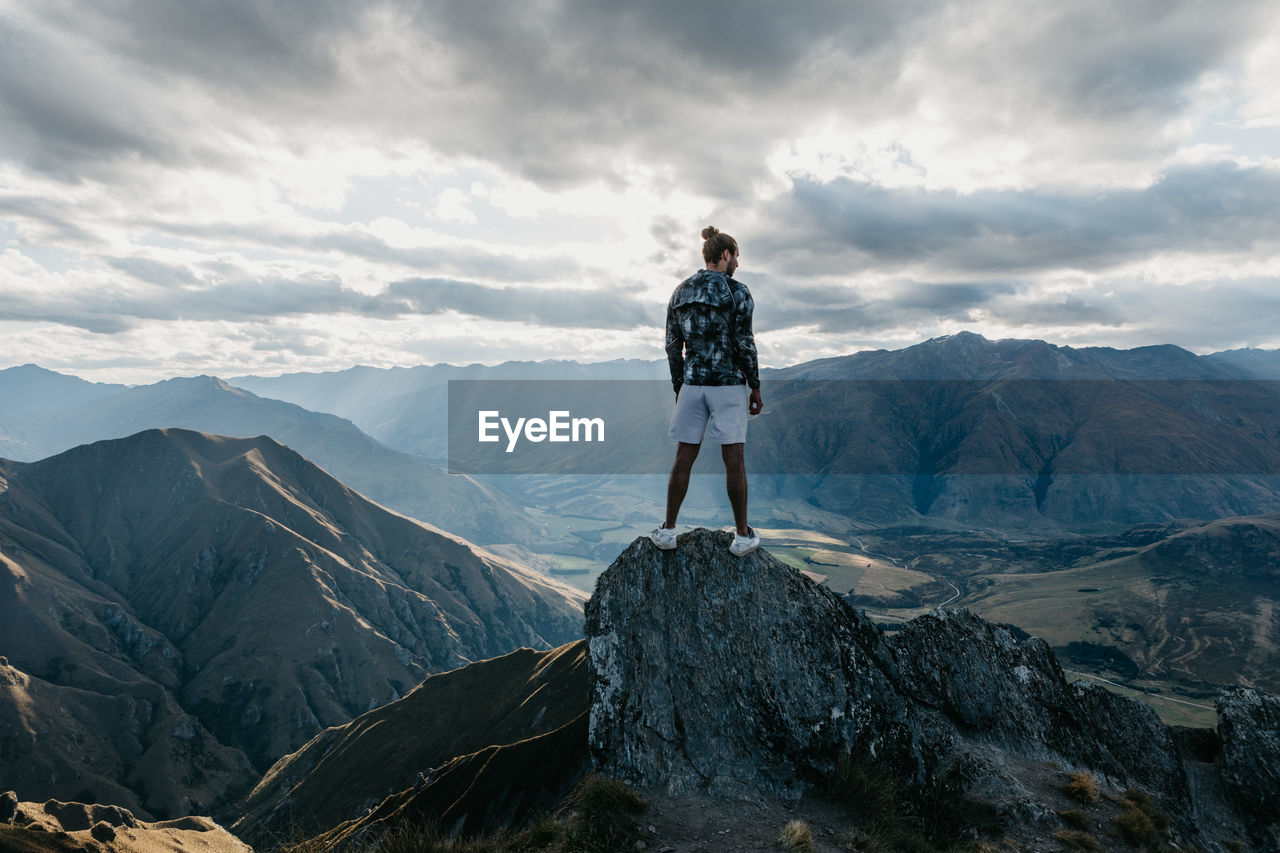 Rear view of man standing on cliff