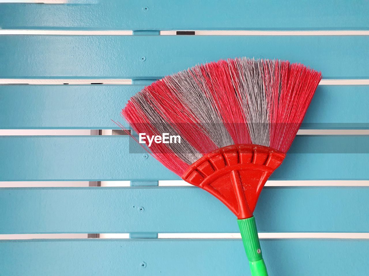 Cobweb broom on blue wall. household equipment concept