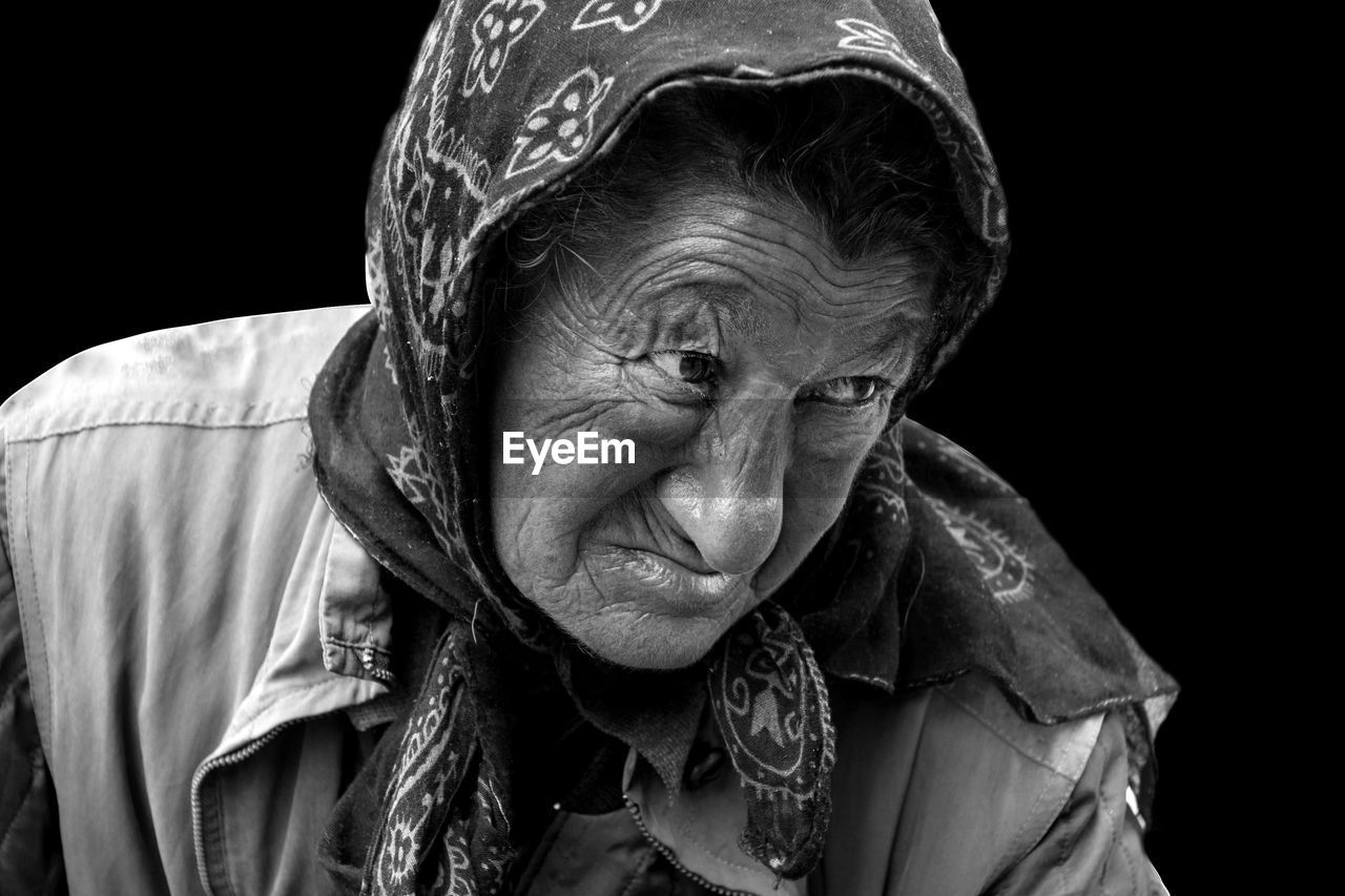 Senior woman looking away against black background