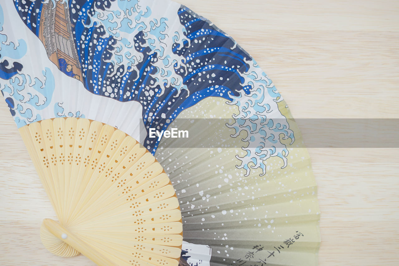fashion accessory, pattern, indoors, art, hand fan, close-up, clothing, blue, no people