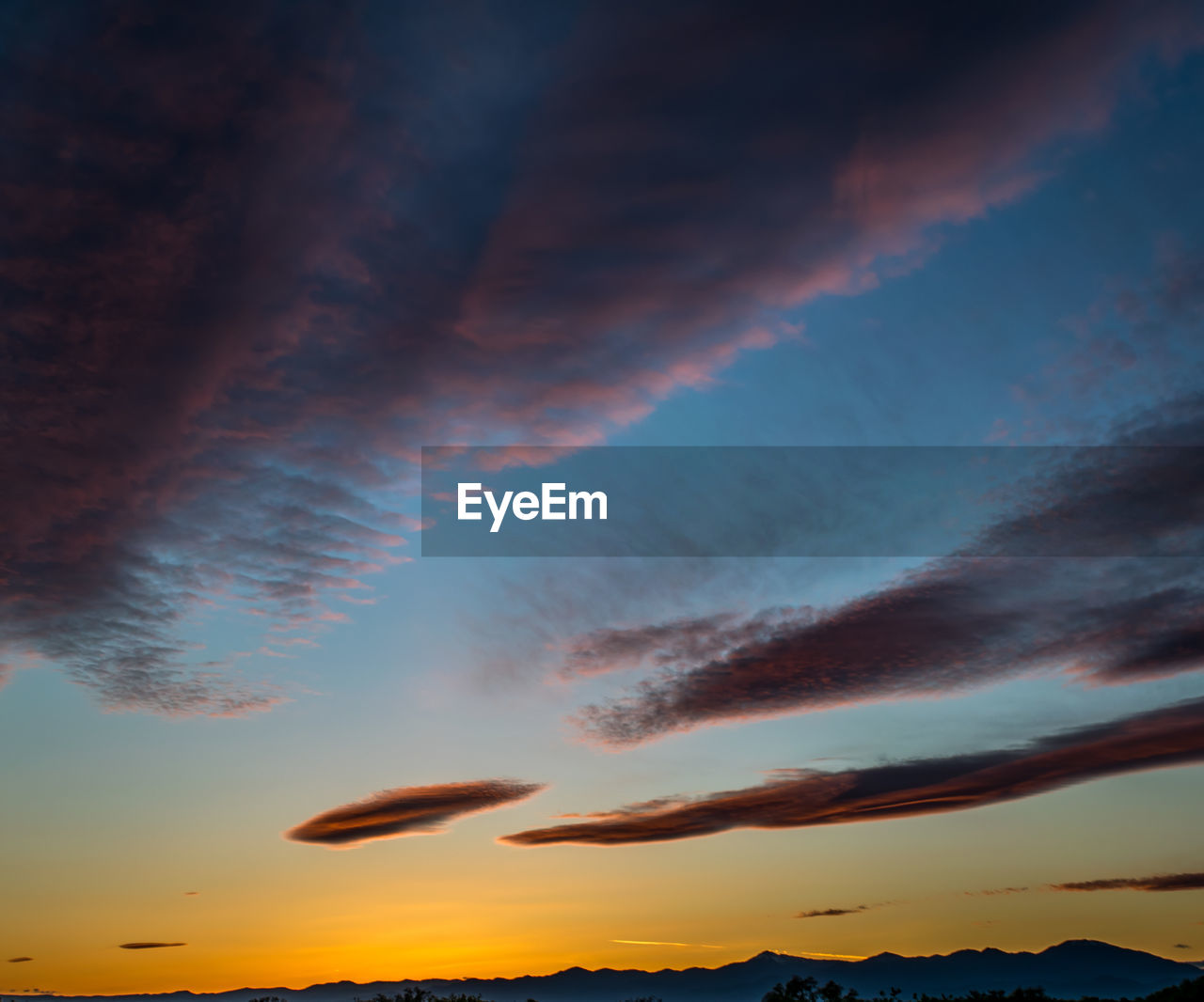 Low angle view of cloudy sky at sunset