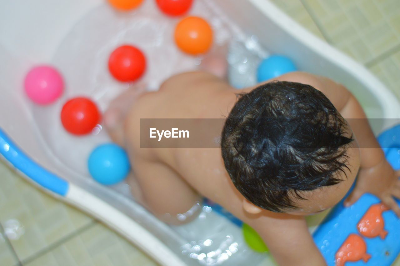 High angle view of naked baby boy in bathtub at home