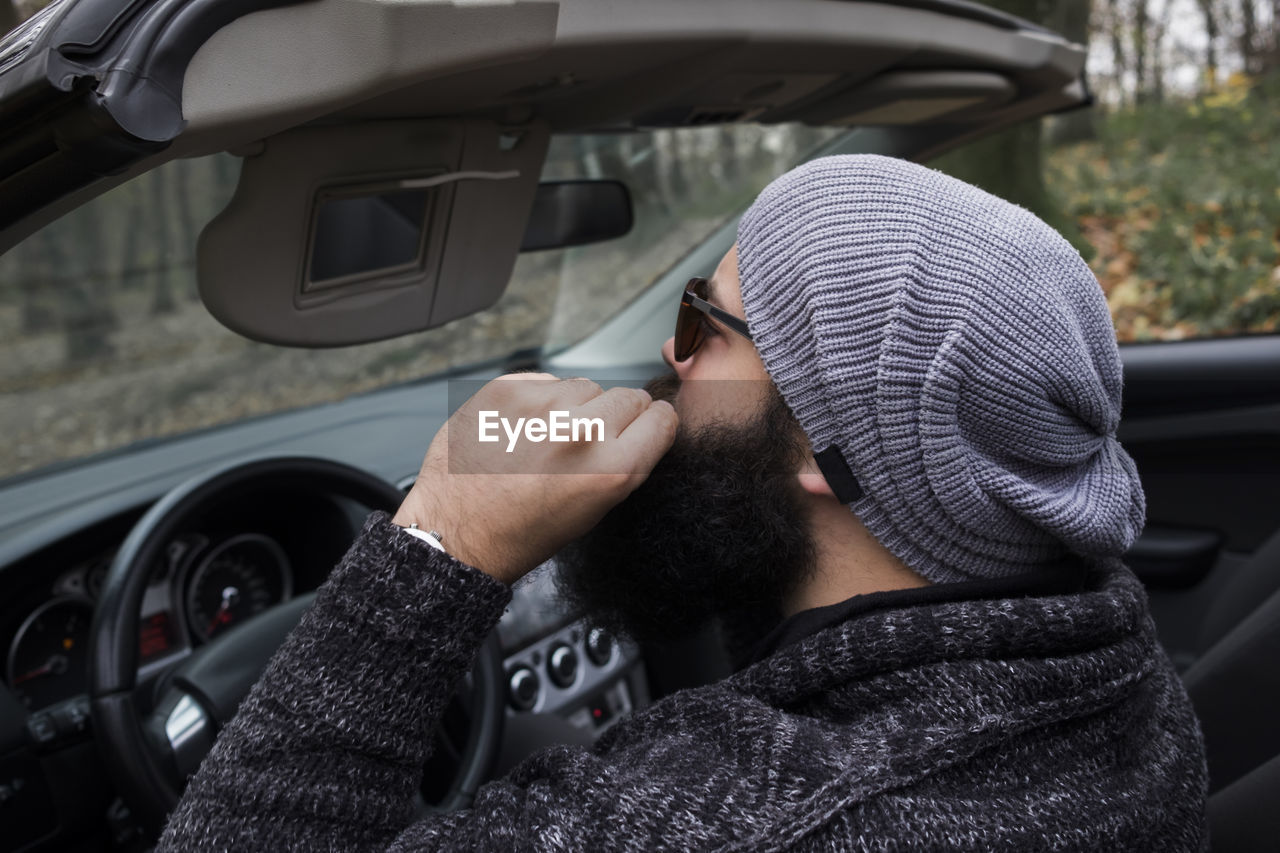 Man wearing knit hat sitting in car