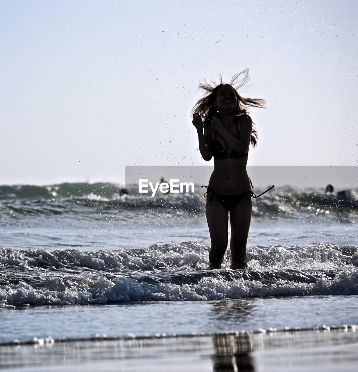 FULL LENGTH REAR VIEW OF WOMAN STANDING ON BEACH