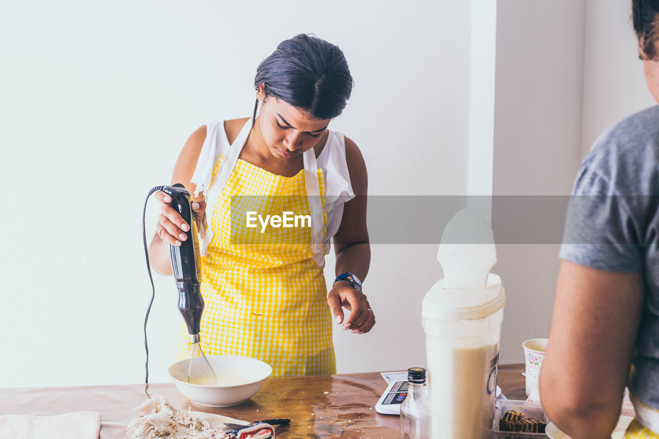 Young woman preparing food while standing at table