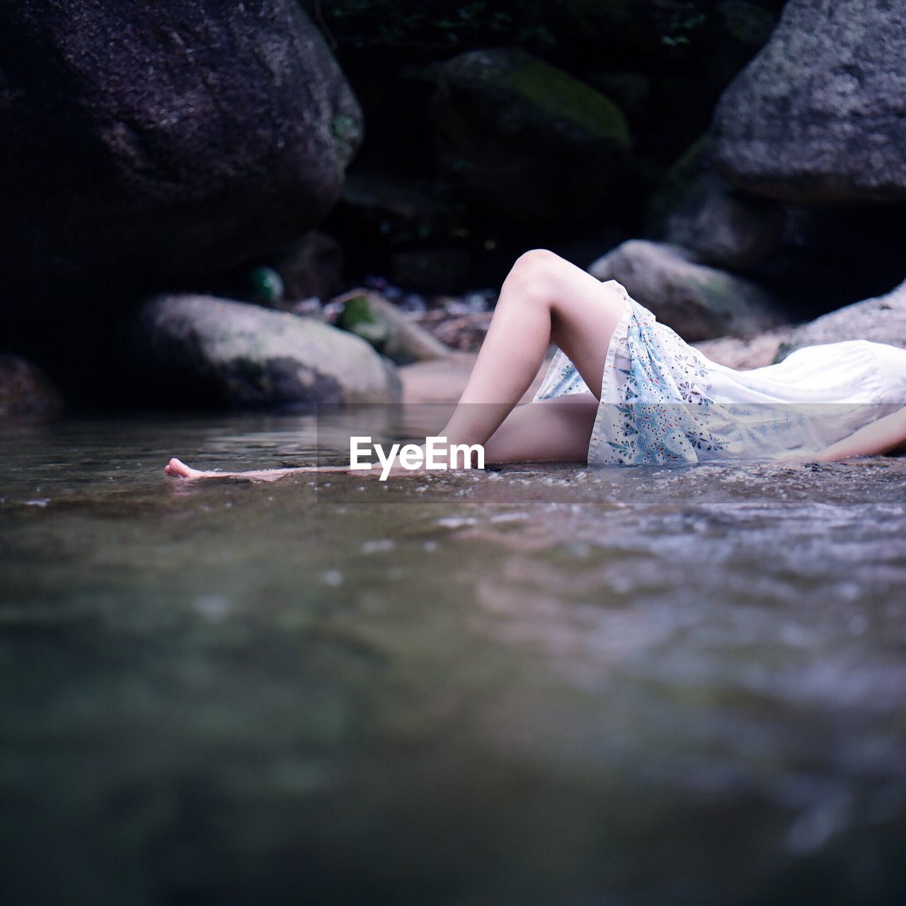 Low section of woman lying in water