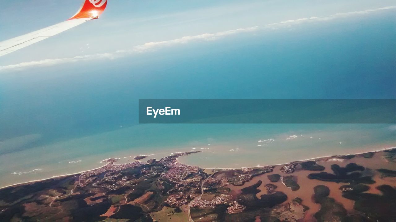 AERIAL VIEW OF SEA BY MOUNTAIN AGAINST SKY