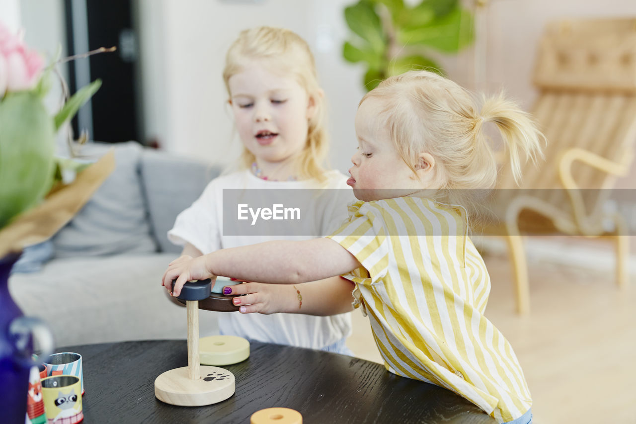 Sisters playing with stacking tower