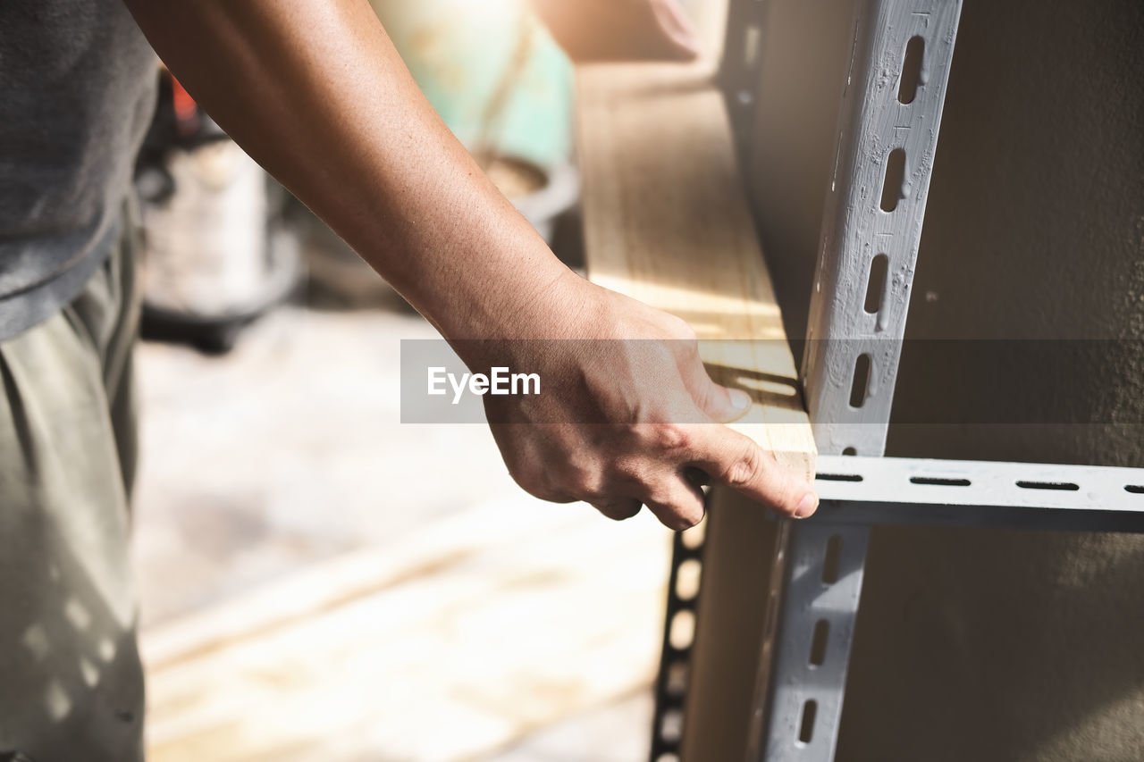 MIDSECTION OF MAN WORKING AT MACHINE
