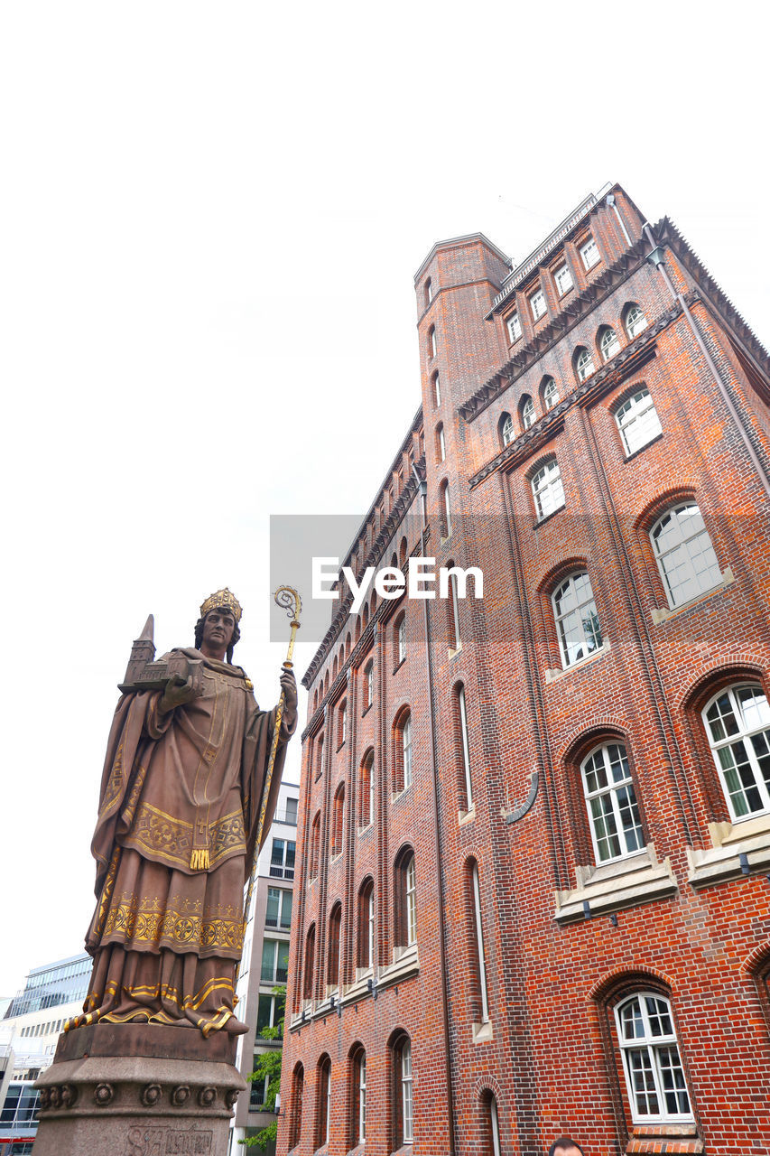 LOW ANGLE VIEW OF STATUE AGAINST HISTORIC BUILDING AGAINST CLEAR SKY