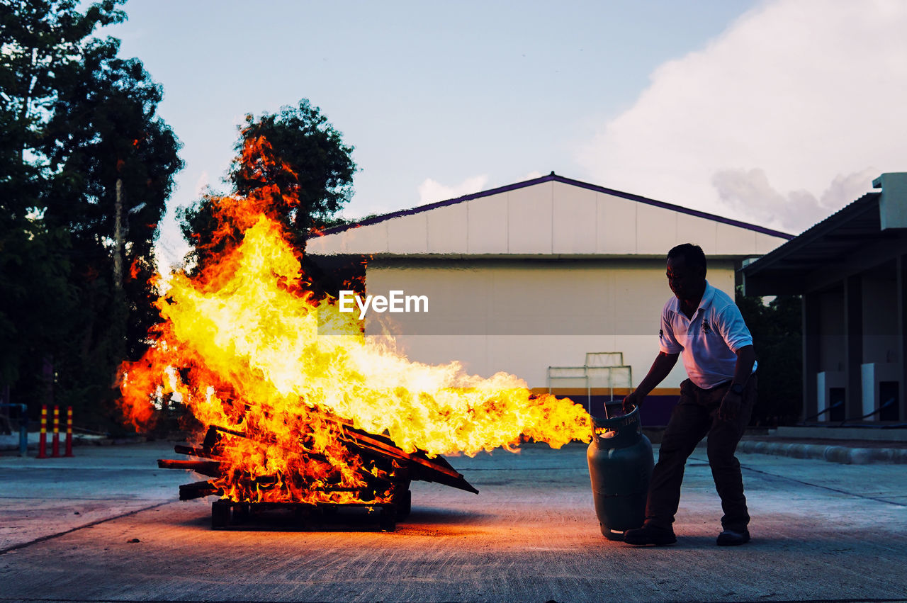 Man holding burning gas cylinder in city