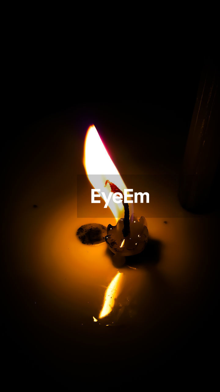 CLOSE-UP OF BURNING CANDLE