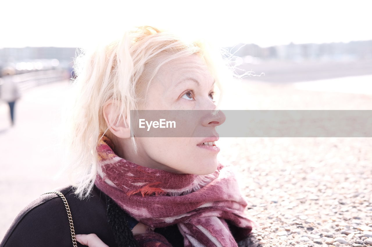 Close-up of mature woman looking up at beach