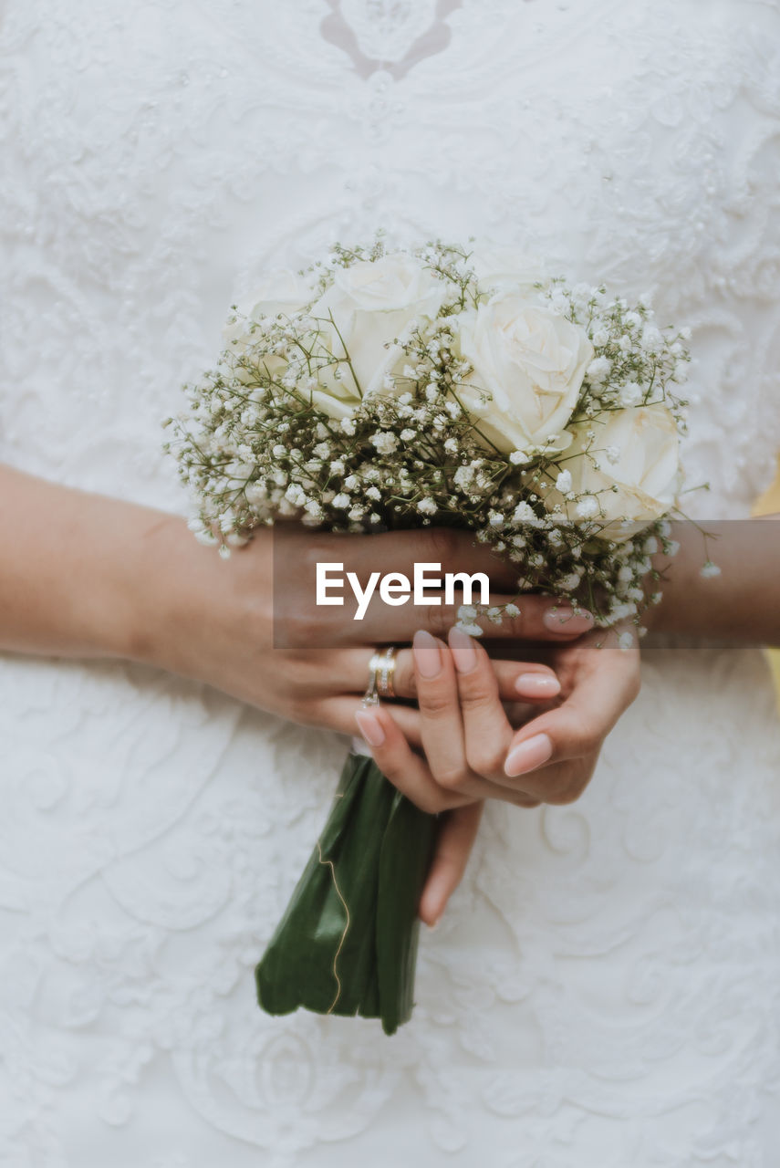 Wedding flowers bouquet in hands of the bride close up