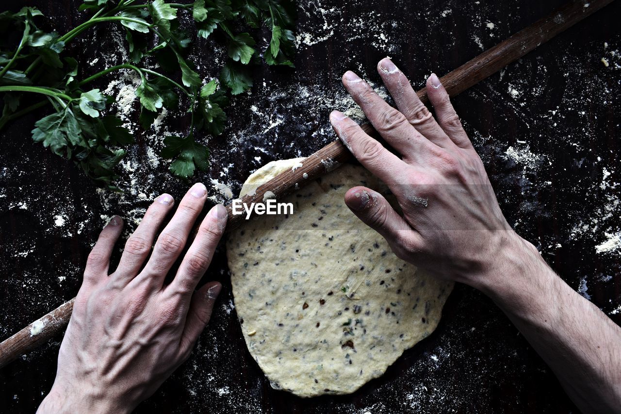 Close-up of hands rolling dough