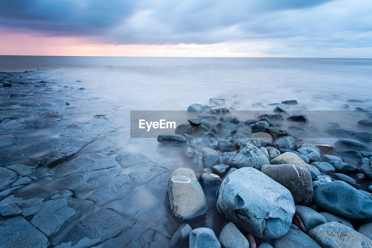 Scenic view of sea shore against sky during sunset