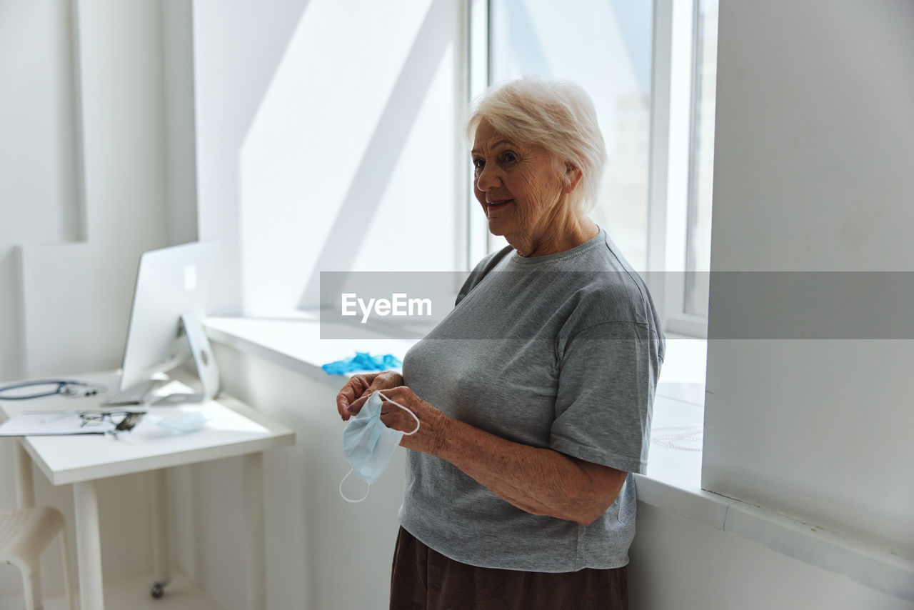 Woman standing by window at home