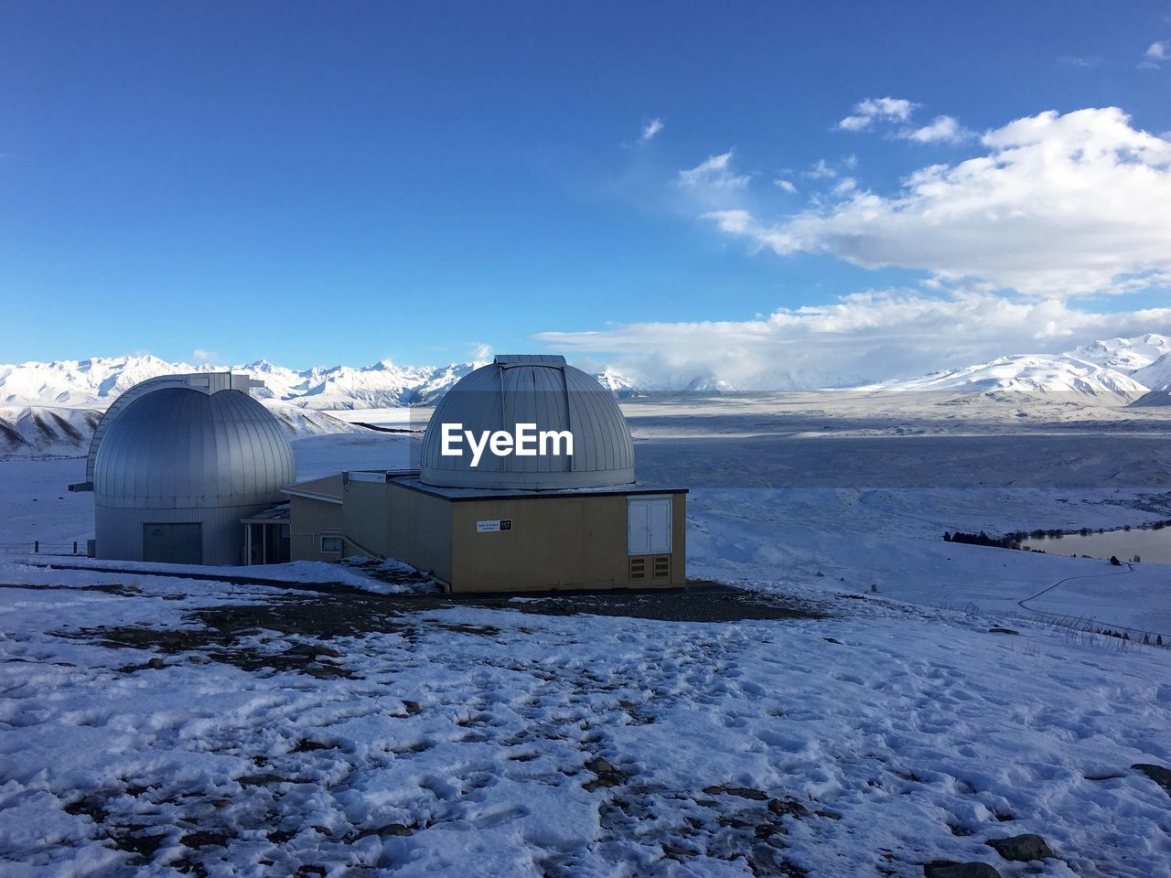 Winter snow view from the top of a sky observatory with big telescopes and snow-capped mountains.
