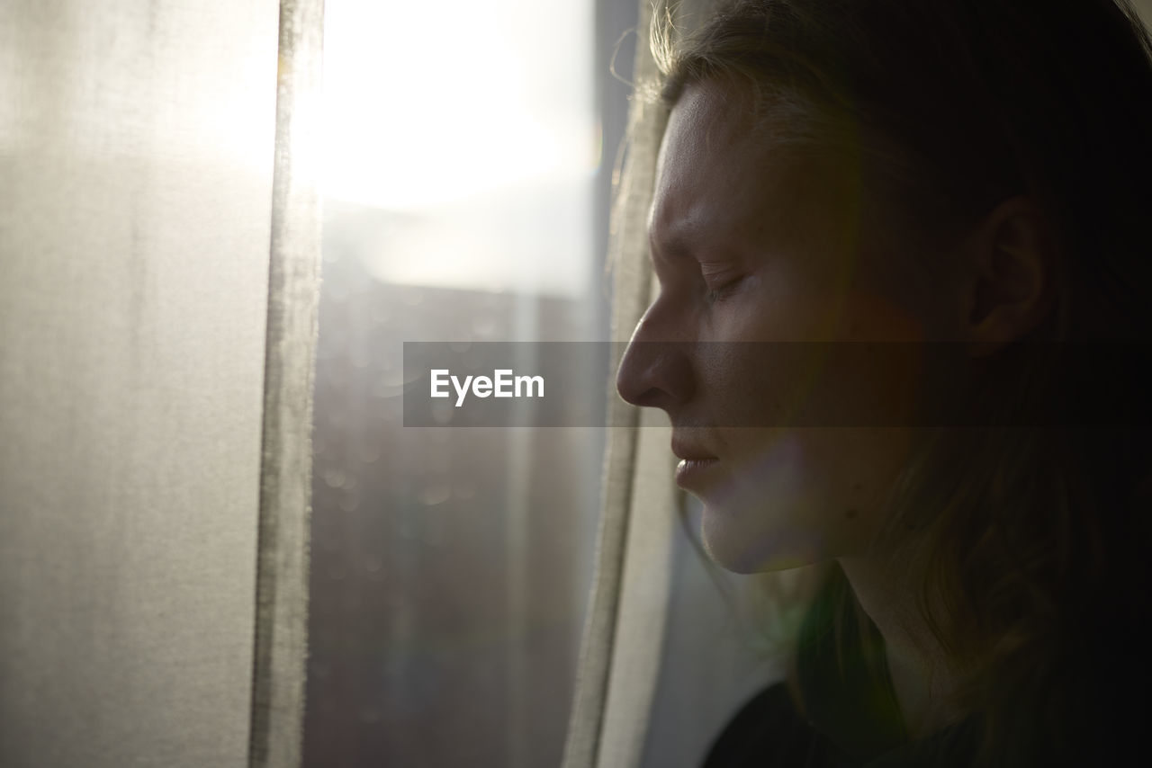 View of woman standing in front of window