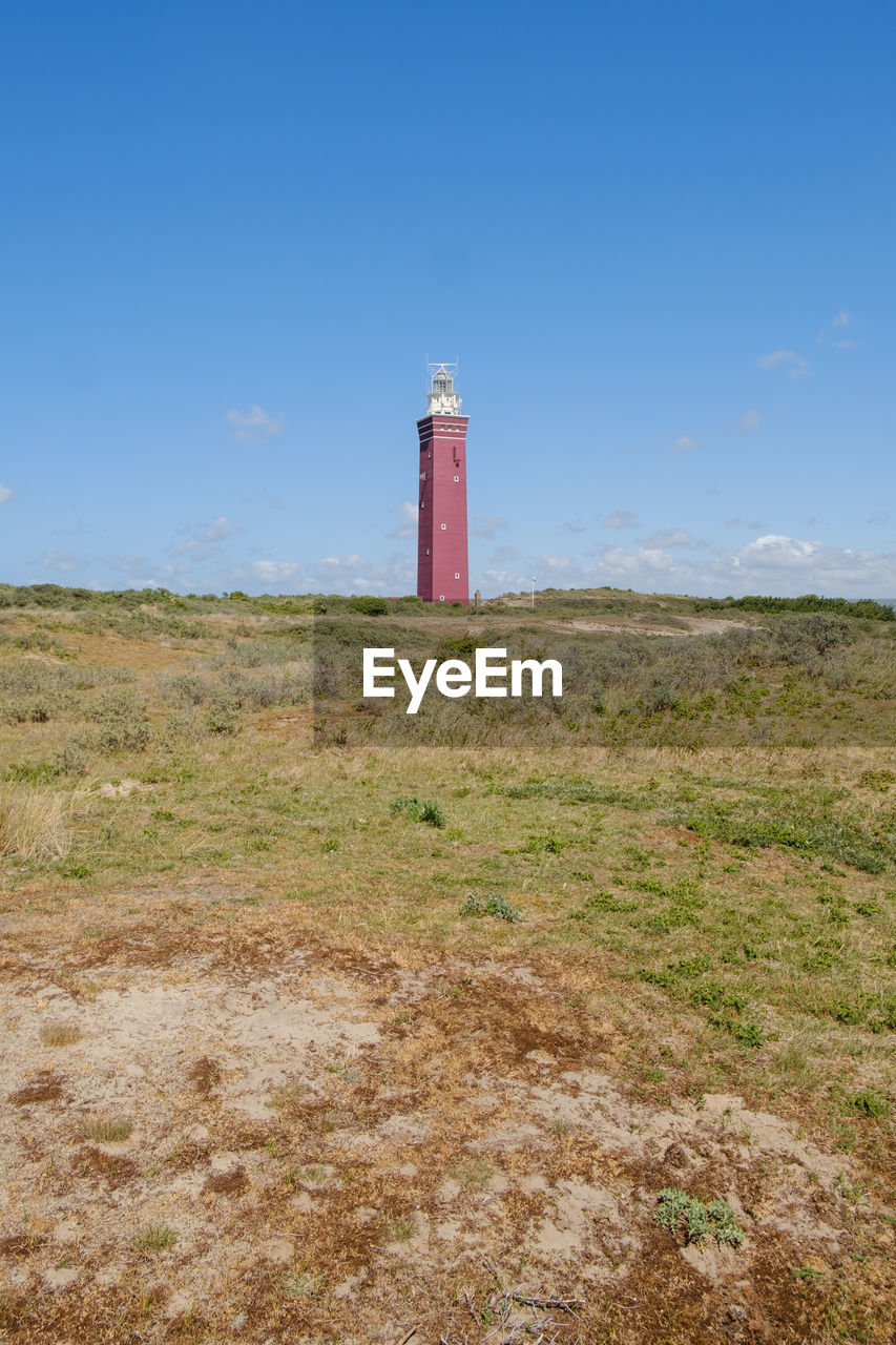 lighthouse by sea against blue sky