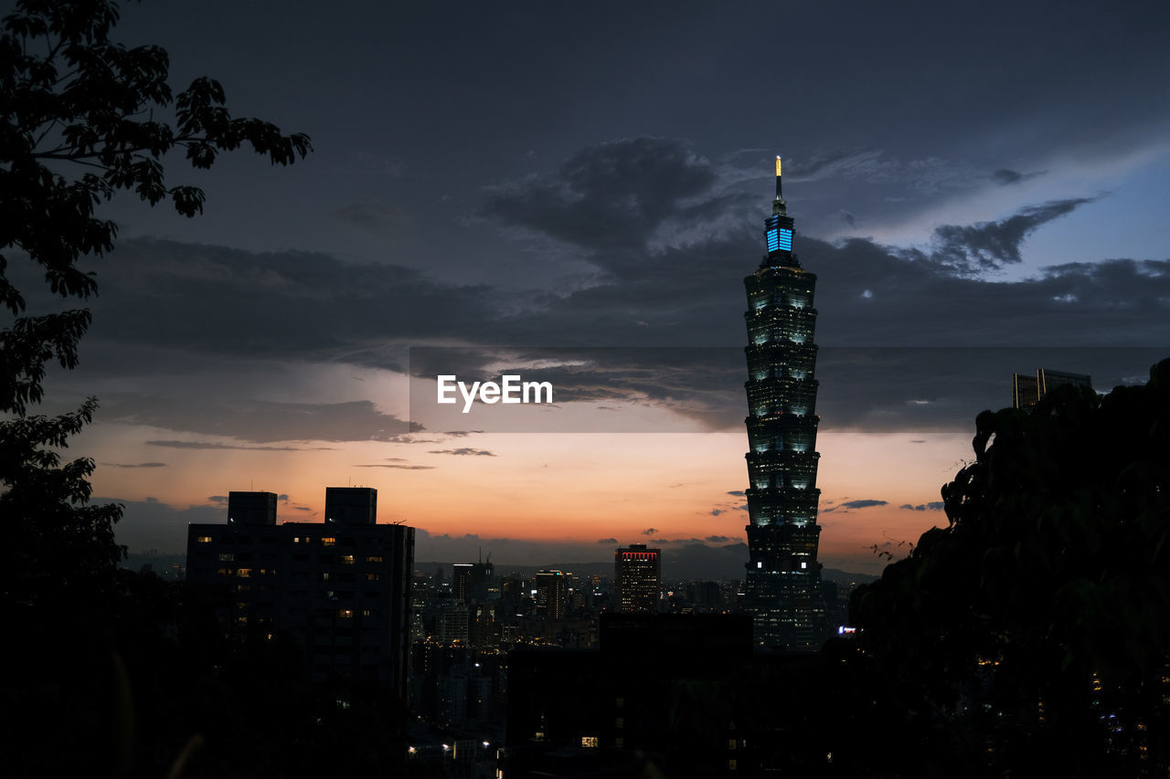 SILHOUETTE OF BUILDINGS AGAINST CLOUDY SKY