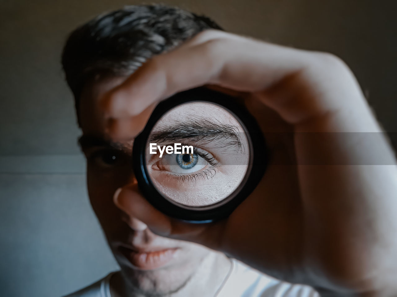 Close-up portrait of boy looking through camera lens