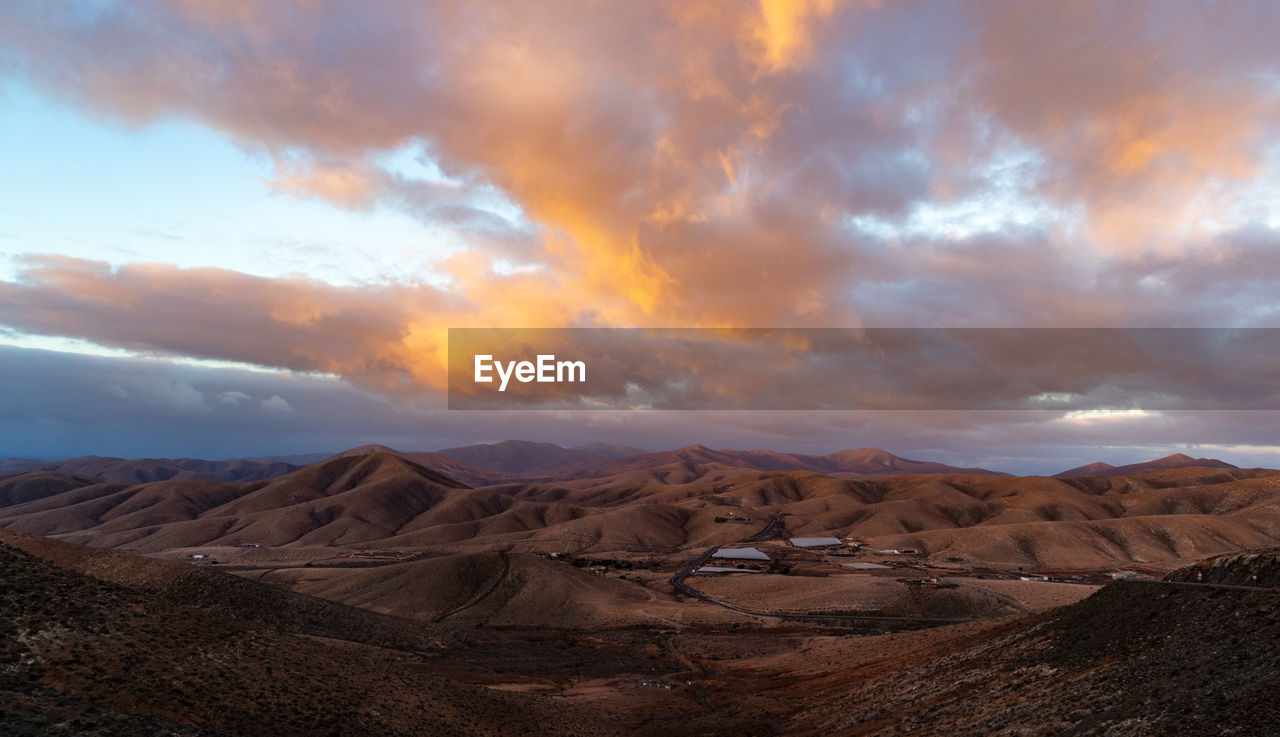 Scenic view of desert against sky during sunset