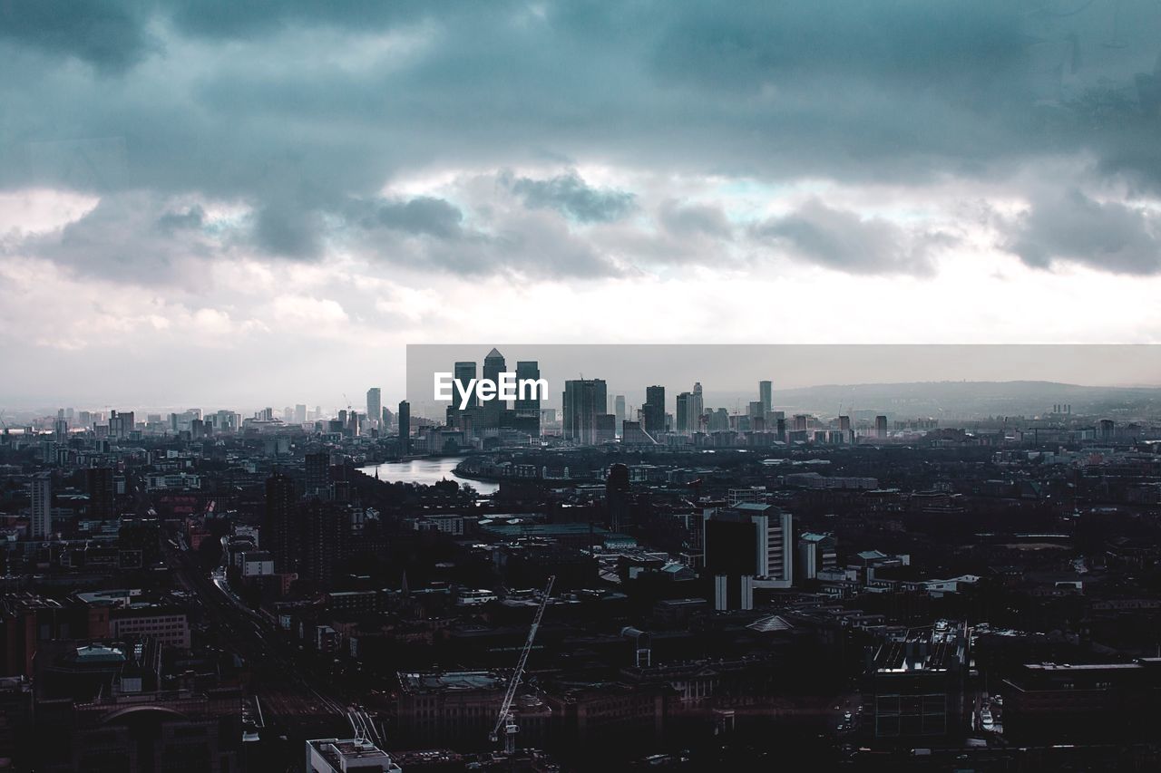 View of cityscape against cloudy sky