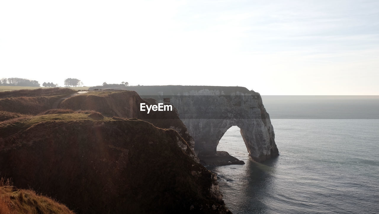 Rock formations by sea against sky