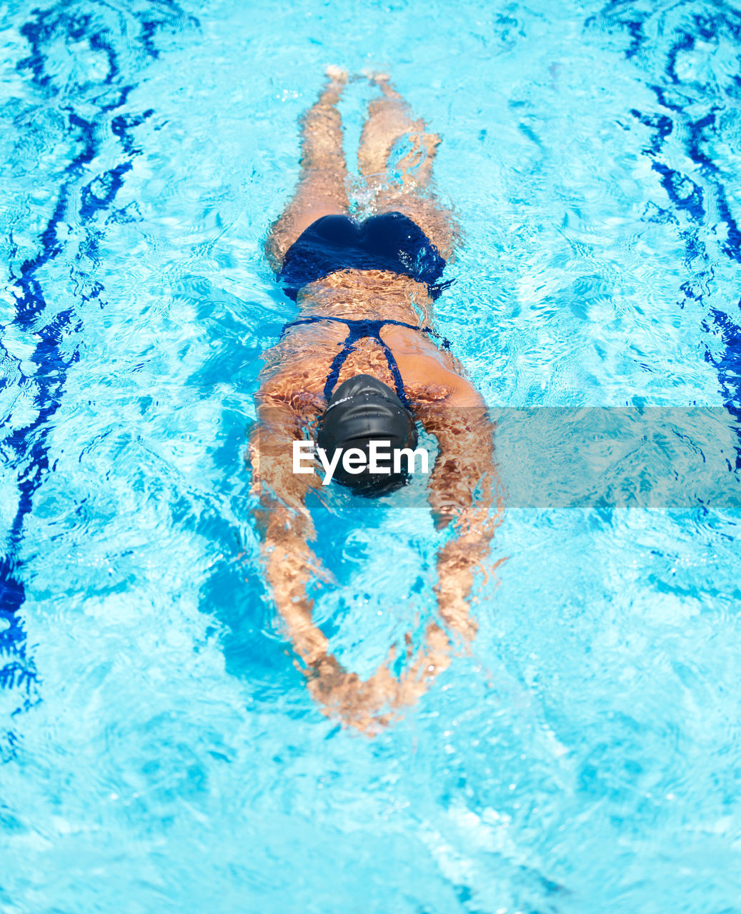 high angle view of shirtless boy swimming in pool