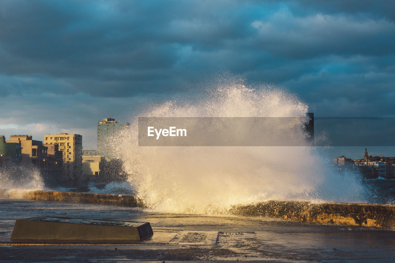 Waves splashing on sea against sky