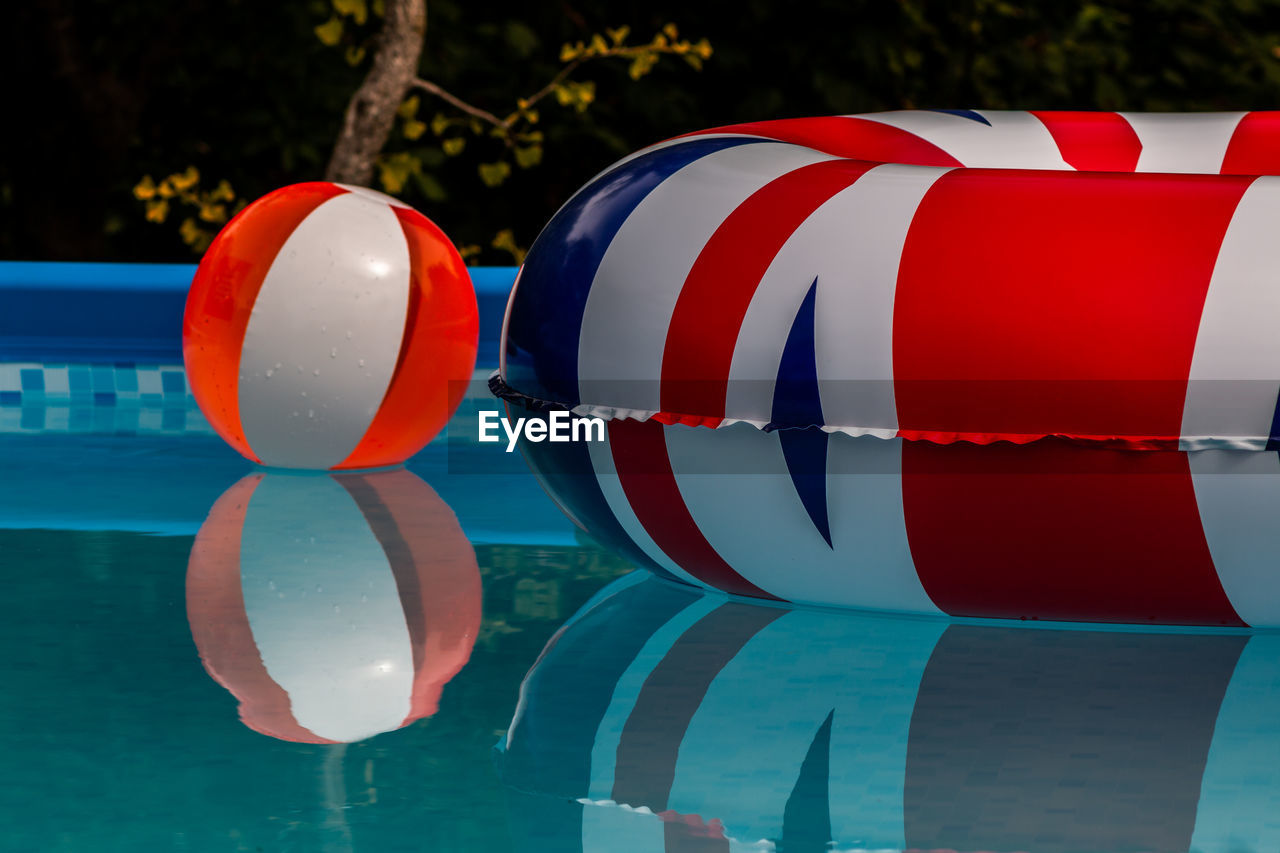 Inflatable ring and ball floating on swimming pool