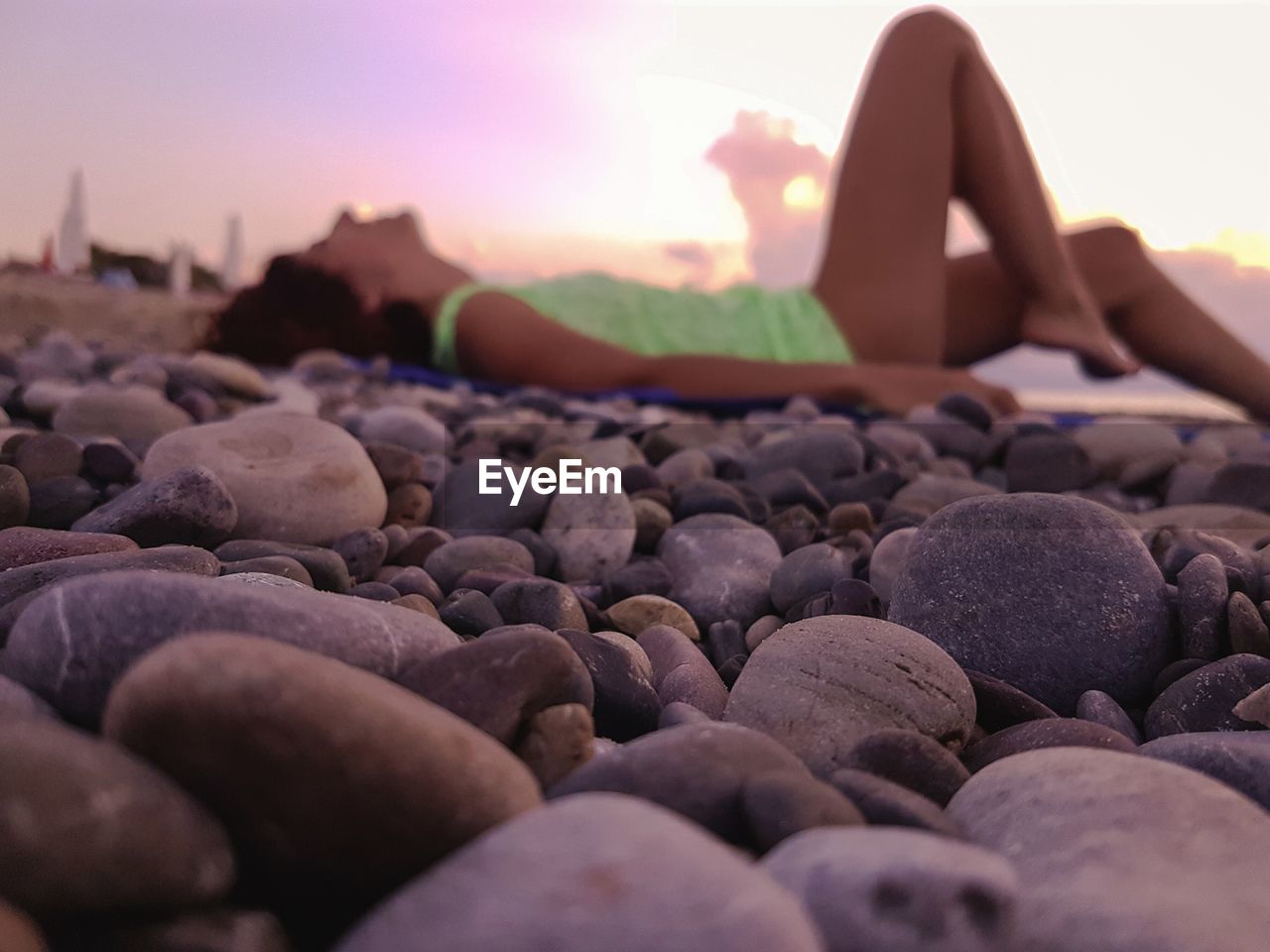 Woman lying at beach during sunset