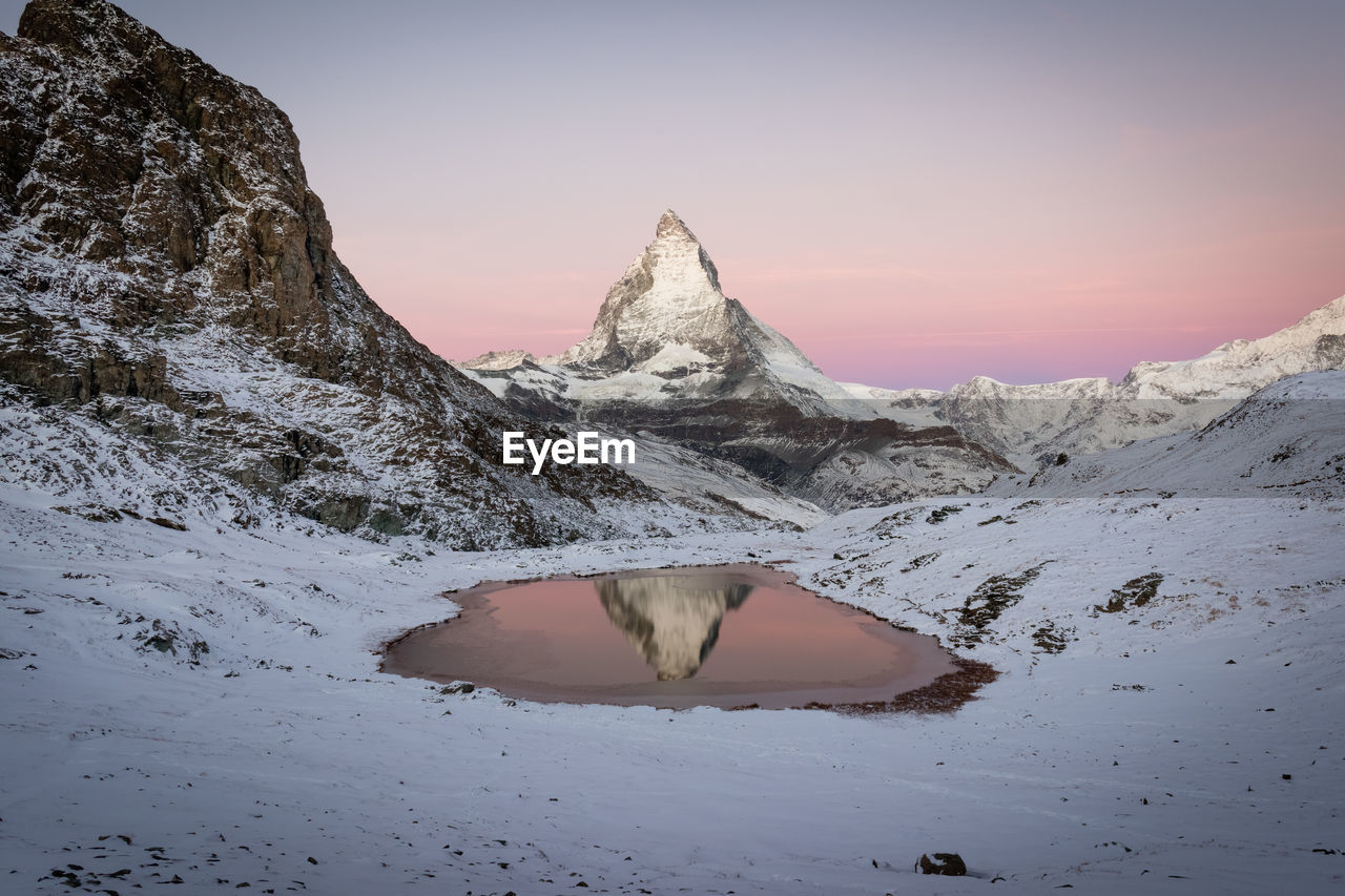 Snowcapped mountain against sky during sunset