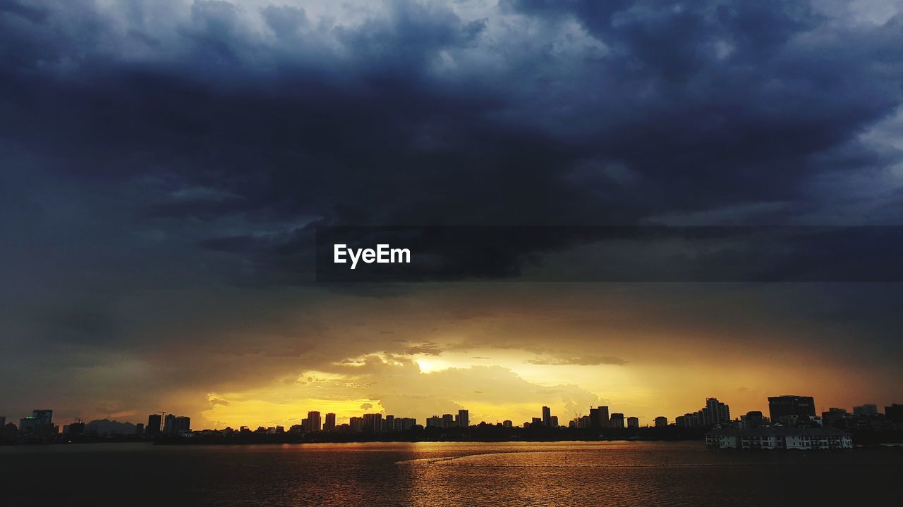 SILHOUETTE BUILDINGS AGAINST SKY AT SUNSET