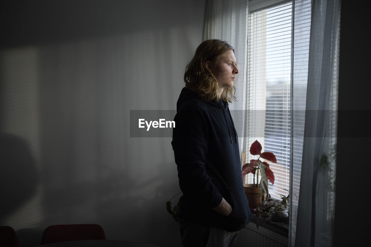 Sad woman looking through window