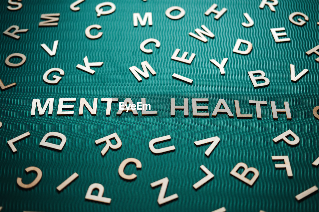 Mental health word from wooden letters. mental health text on green background with many other