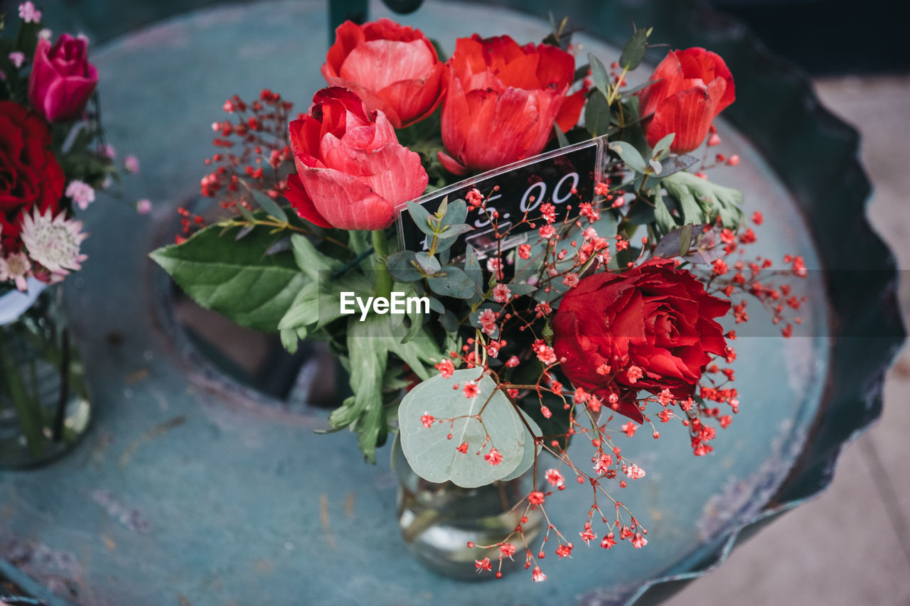 High angle view of small red roses bouquet with a price tag