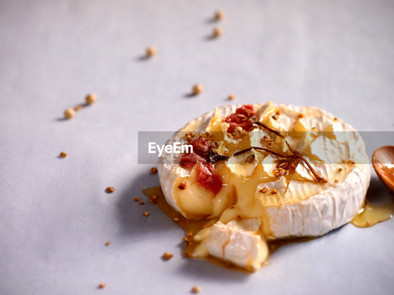 Baked camembert cheese with agave syrup and pickled cherry blossoms on top