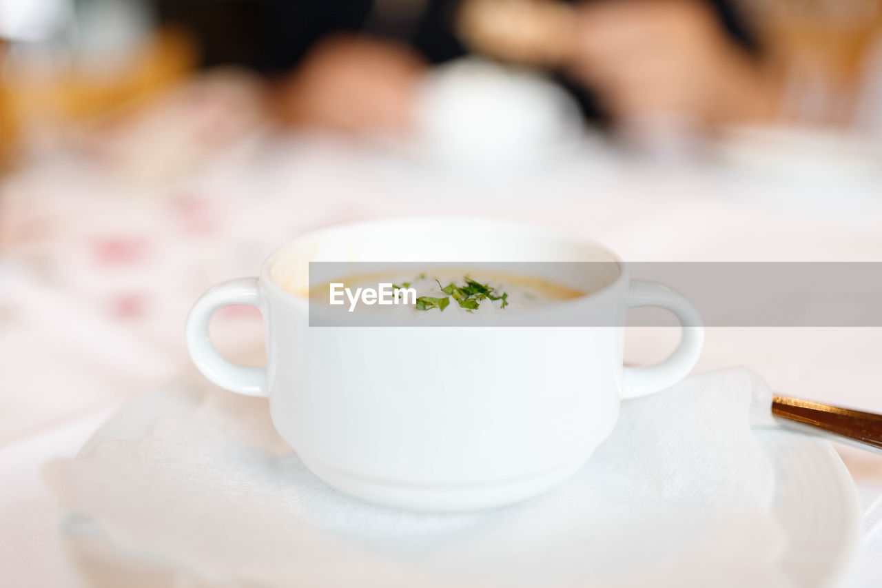 Close-up of soup cup on table