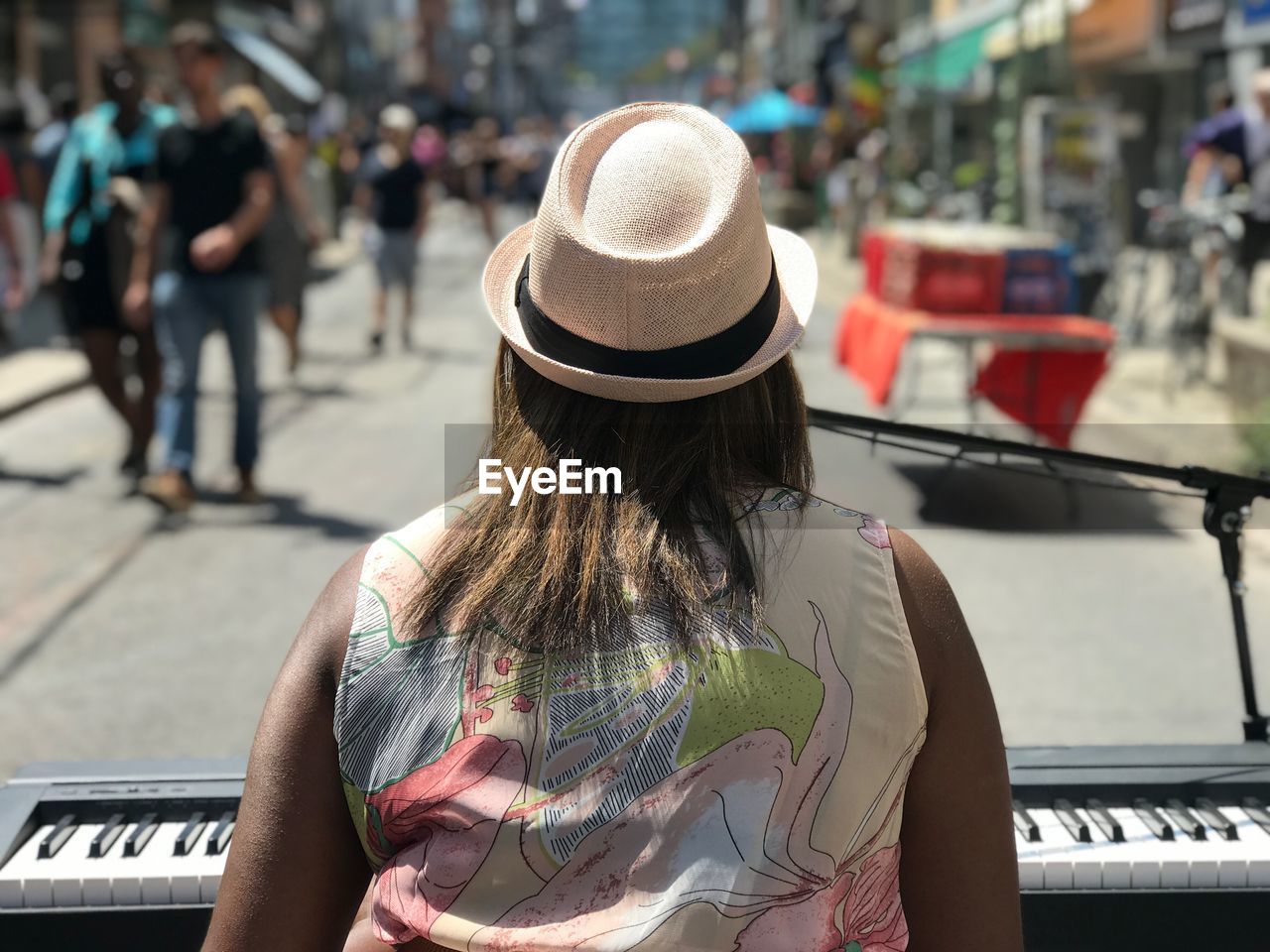 Rear view of woman performing on street in city