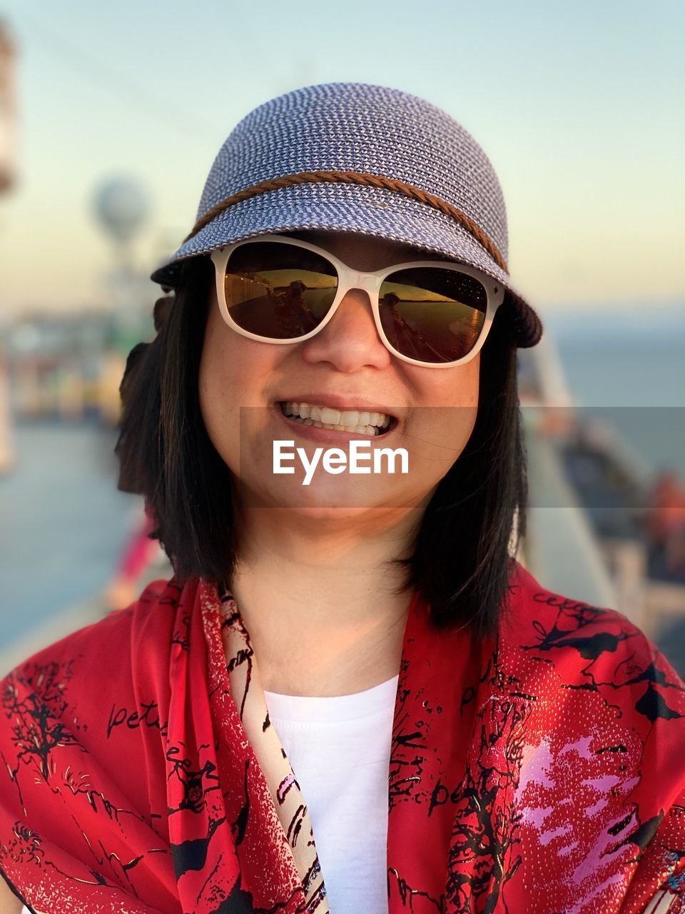 Portrait of smiling woman wearing sunglasses and hat outdoors