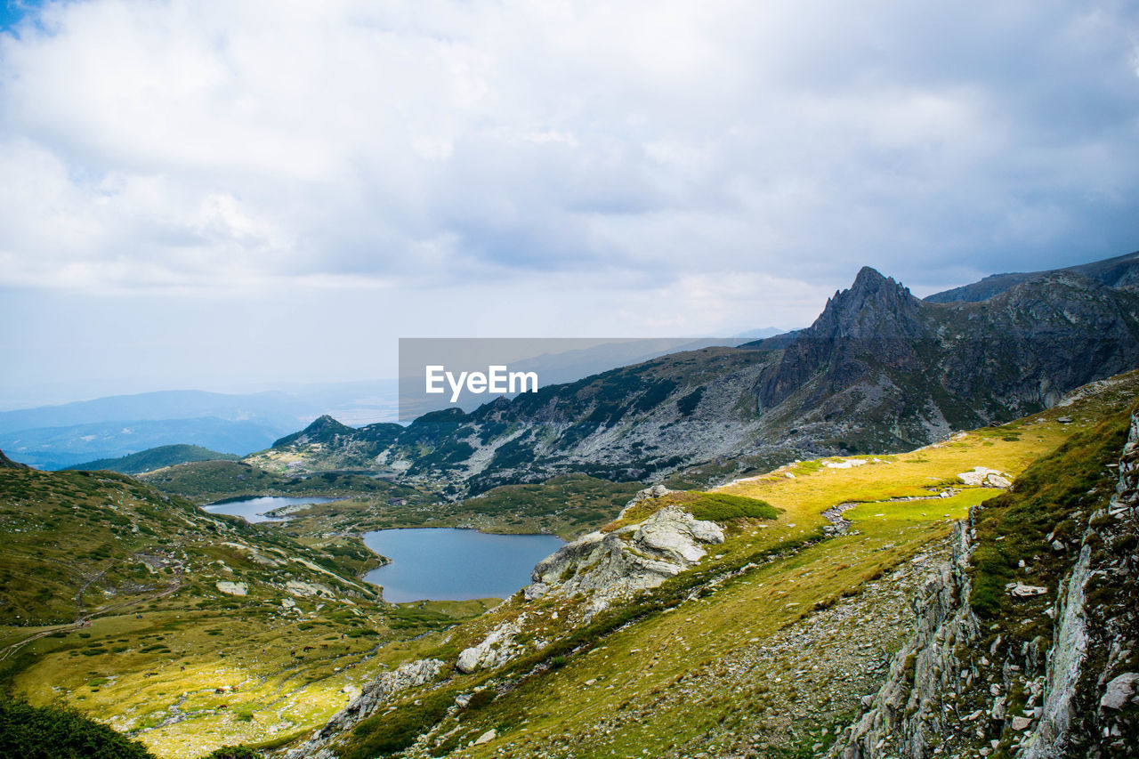 Scenic view of mountains against cloudy sky