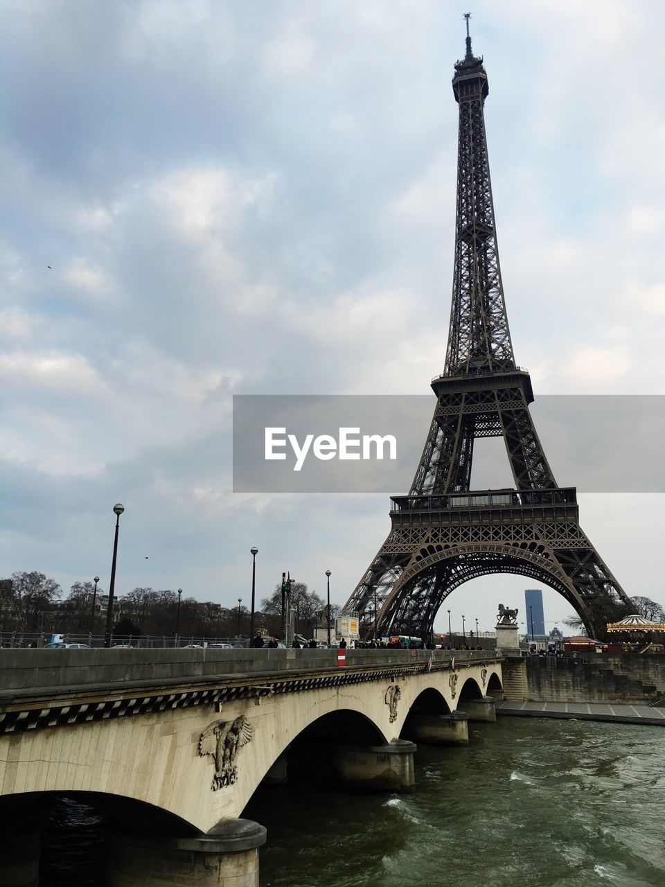 Low angle view of eiffel tower against cloudy sky