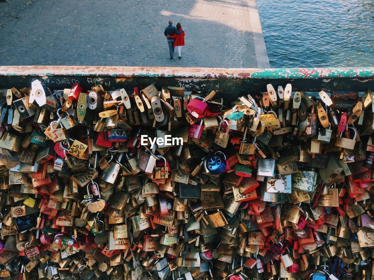 High angle view of padlocks on railing