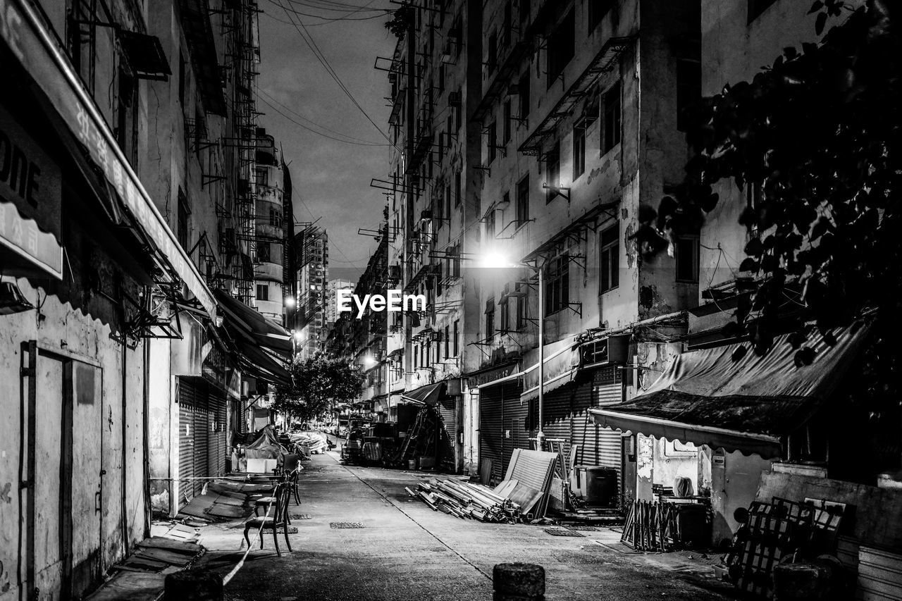 Street amidst buildings in city at night