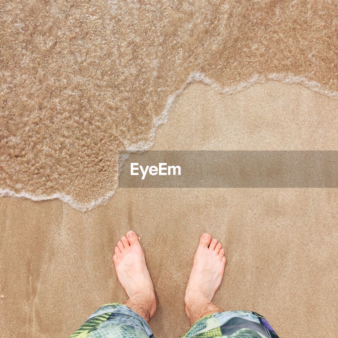 High angle view of man standing on beach sand